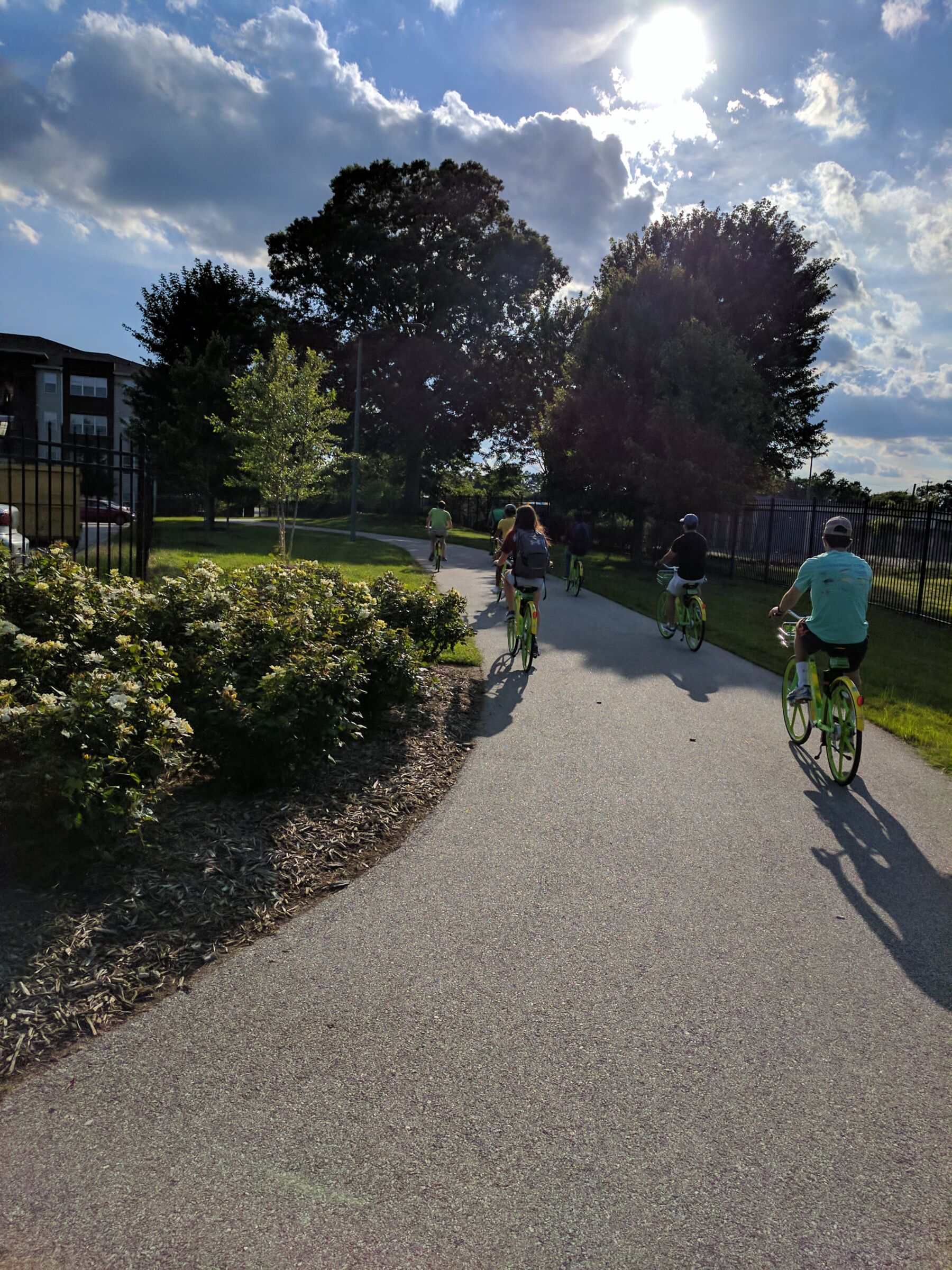 Bicyclists riding e-bikes along Downtown Greenway in Greensboro