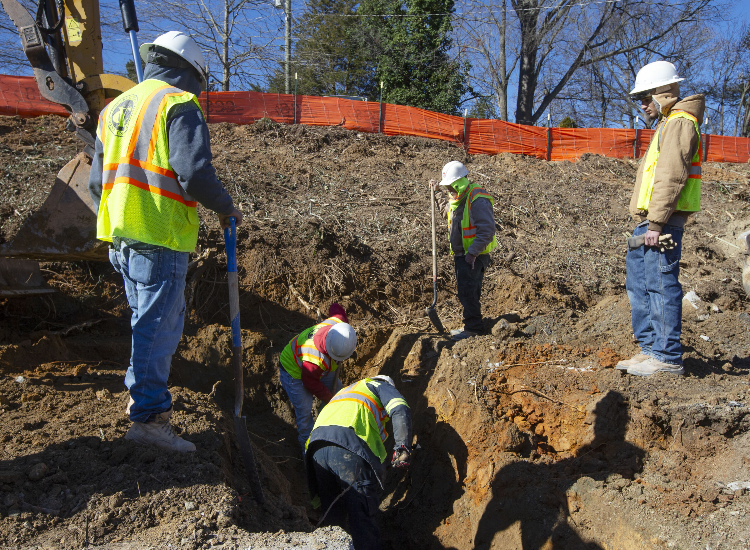 Construction workers digging trench along Downtown Greenway